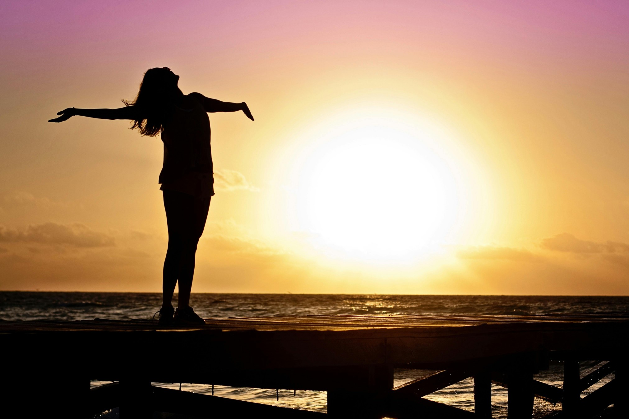 Silhouette de femme devant un coucher de soleil. Elle a de l'argent de côté à 40 ans.